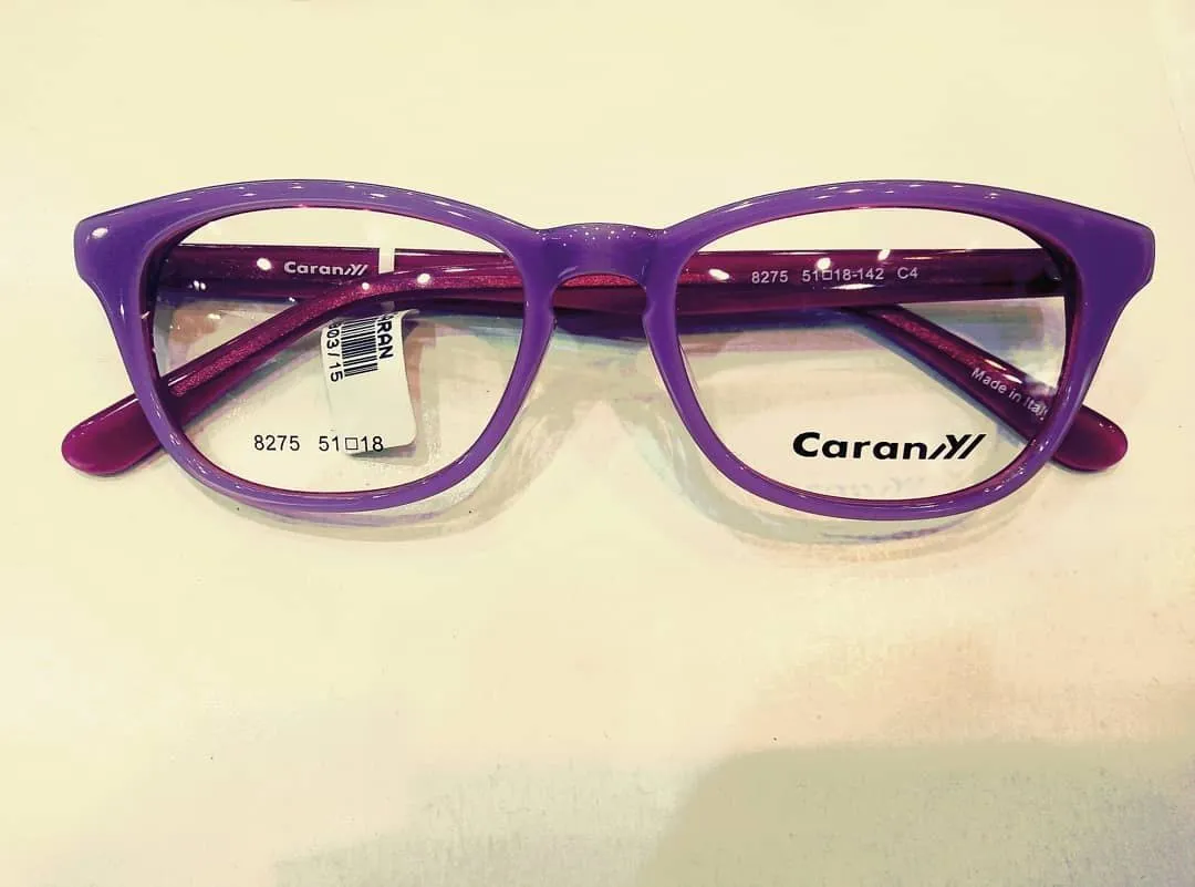 Purple acetate frame with magenta temples on a cream counter