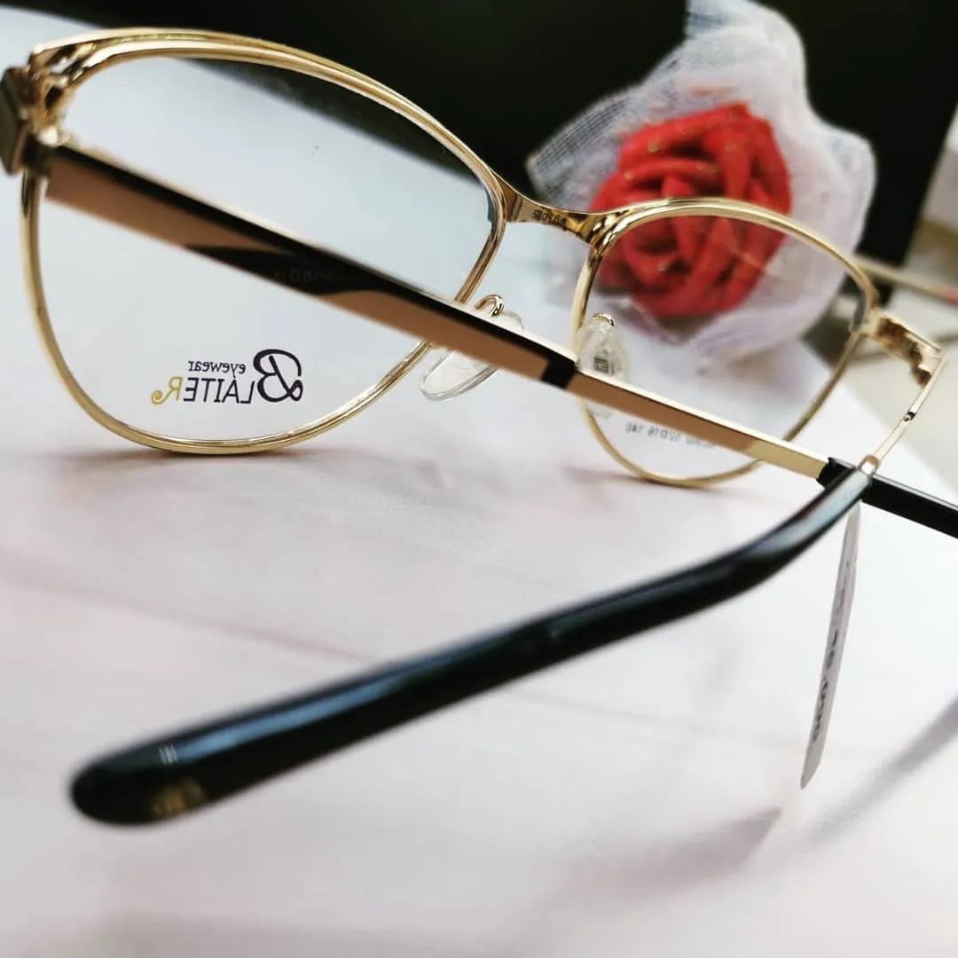 Gold cat-eye glasses with black temples, close up