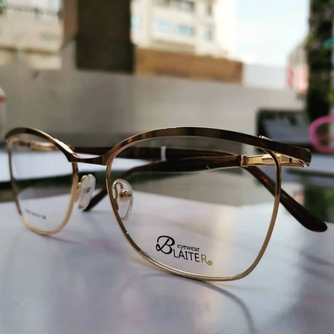 Gold metal frame with tortoise temples on a table by a bright window